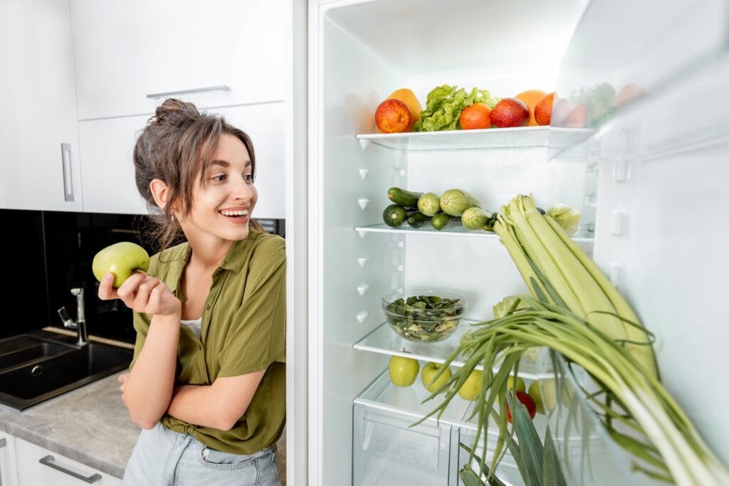 Woman near the fridge full of healthy food jajandikitid Menyimpan Bahan Makanan di Kulkas