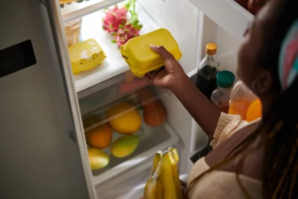 Cara Menyimpan Bahan Makanan di Kulkas Supaya Awet Woman Taking Eggs from Fridge